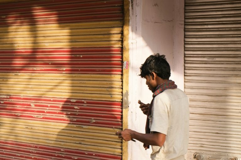 woman in white shirt standing beside red roll up door